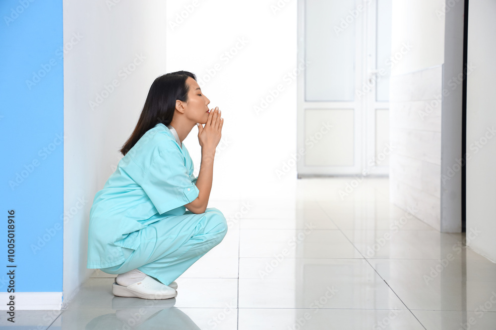 Stressed female Asian medical intern in clinic Stressed female Asian medical intern in clinic