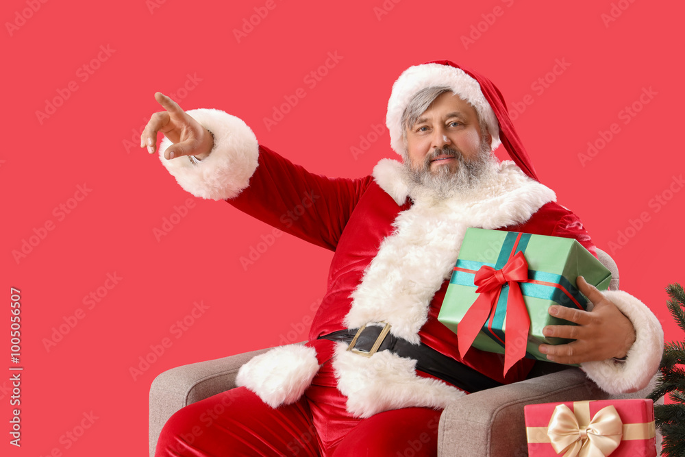 Santa Claus sitting sitting on armchair with presents against red background Santa Claus sitting sitting on armchair with presents against red background