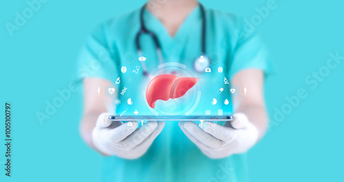 The doctor studies and analyzes the liver on his tablet. Technological concept for the treatment of cirrhosis and hepatitis. The hepatologist is standing on an emerald green photo