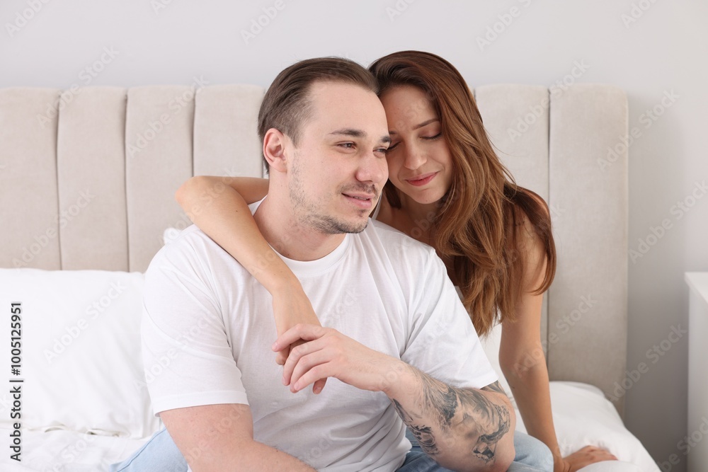 Cute couple spending time together on bed at home Cute couple spending time together on bed at home