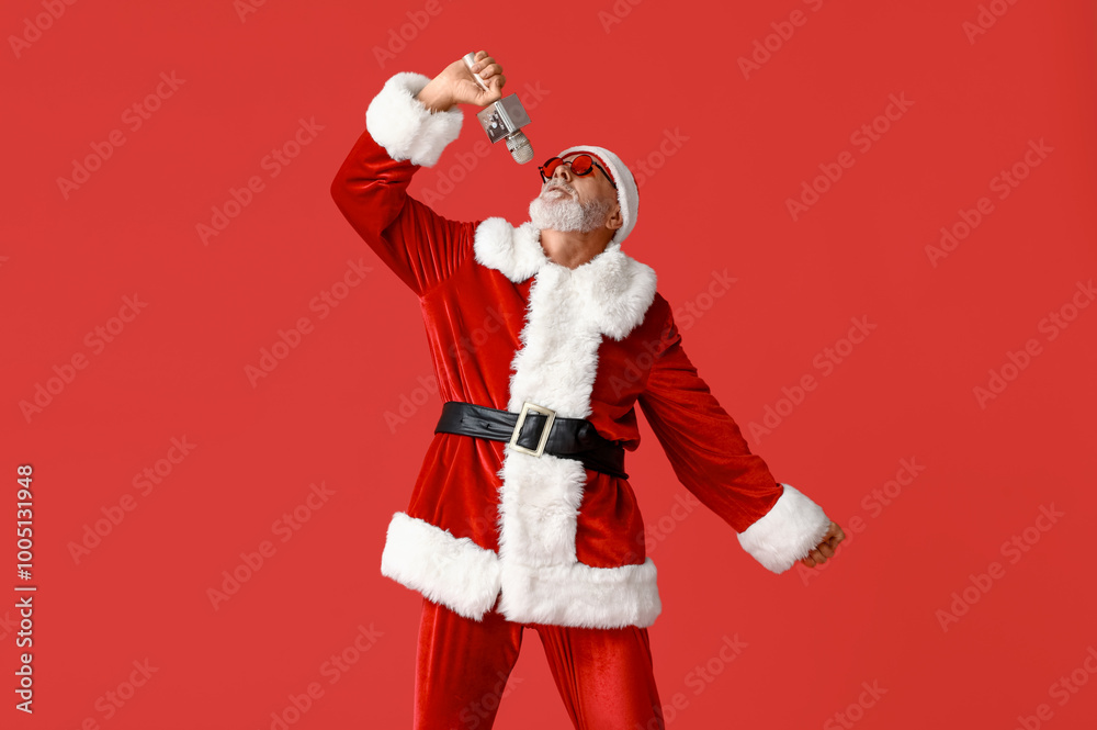 Santa Claus in sunglasses with microphone singing on red background Santa Claus in sunglasses with microphone singing on red background