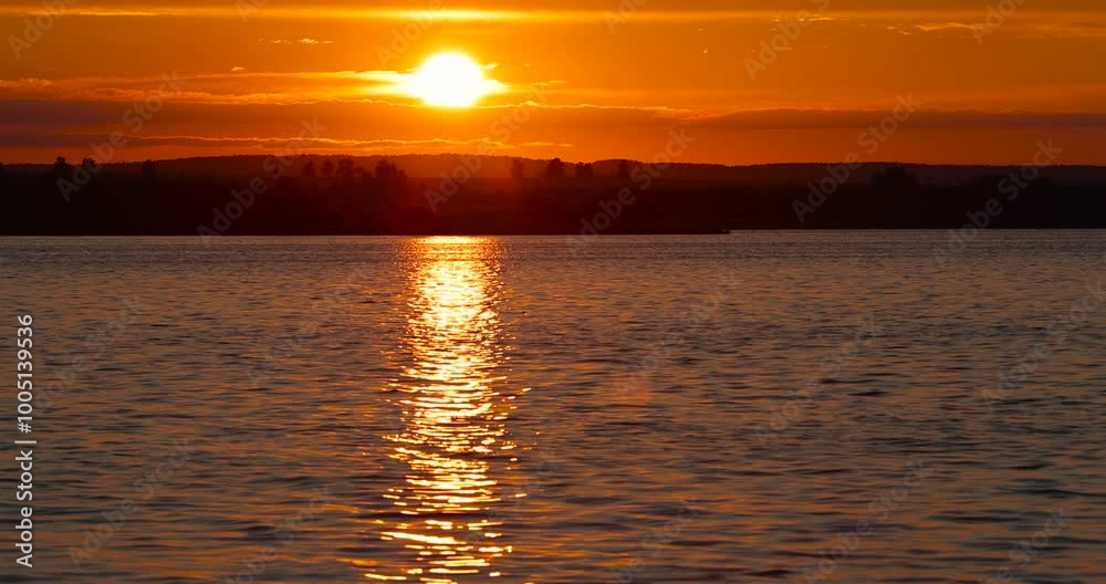 sunset with sun and orange sky on the lake, reflection of the orange sky in the waves on the lake during sunset sunset with sun and orange sky on the lake, reflection of the orange sky in the waves on the lake during sunset