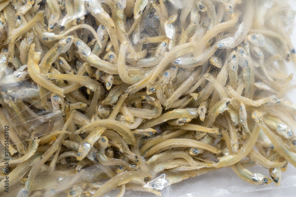 This close-up image showcases a textured mound of dried anchovies, their silvery bodies intertwined and glistening with natural oils. This close-up image showcases a textured mound of dried anchovies, their silvery bodies intertwined and glistening with natural oils.