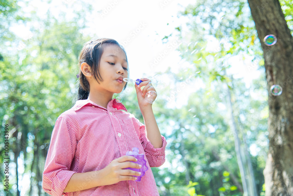 Adorable happy cute girl playful foam bubbles in green playground in summer outdoors. Funny Cheerful girl in the park with happy times. Adorable happy cute girl playful foam bubbles in green playground in summer outdoors. Funny Cheerful girl in the park with happy times.