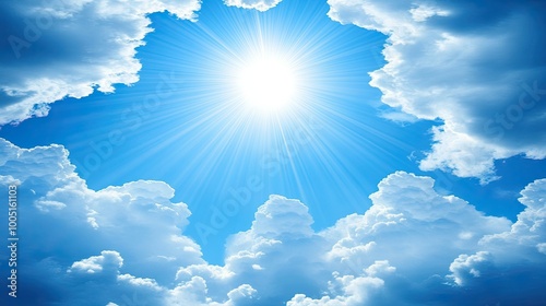 A bright sun shines through fluffy white clouds in a clear blue sky.