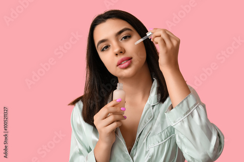 Young woman applying facial...