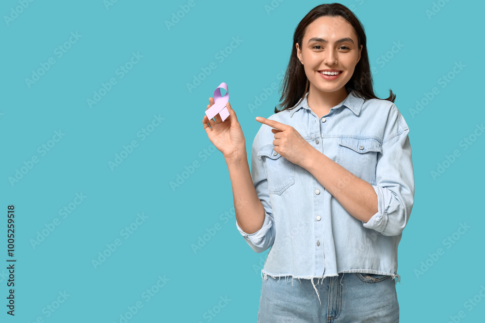Pretty young woman pointing at light purple ribbon on blue background. Testicular cancer awareness concept Pretty young woman pointing at light purple ribbon on blue background. Testicular cancer awareness concept