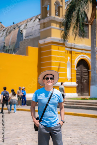 Young Latina men smiling and enjoying his time exploring the vibrant streets of Barranco, Lima, Peru, on a sunny day. photo