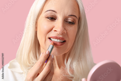 Mature woman applying lipst...