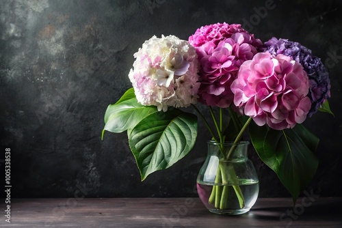 Pink white purple hydrangea flowers in vase with monstera leaf on black background aerial view