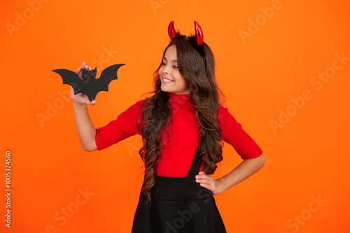 All Hallows party celebration. All Hallows bat. Girl devil has fun at Halloween party. Happy Halloween. Girl devil ready for Halloween party isolated on orange. Trick or treat