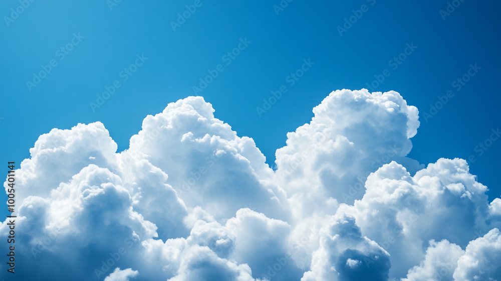 Naklejka premium Fluffy white clouds against a clear blue sky during midday in a serene atmosphere