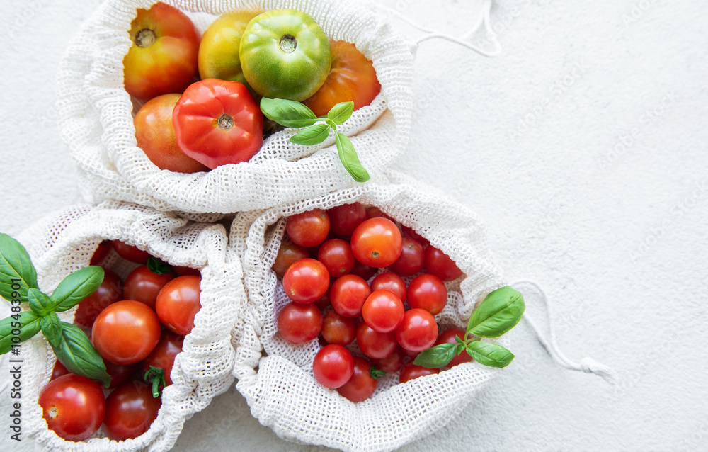 Freshly harvested tomatoes in eco-friendly bags on a light background, perfect for a healthy meal Freshly harvested tomatoes in eco-friendly bags on a light background, perfect for a healthy meal