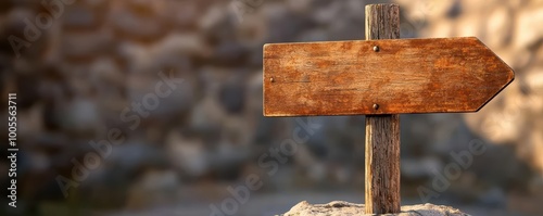 Wooden directional signpost against a rocky background, guiding travelers. photo