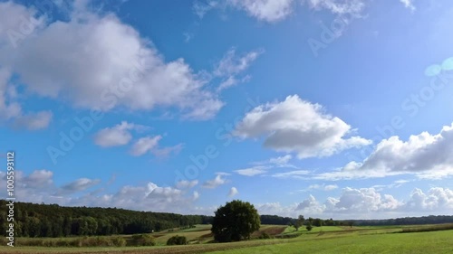 idyllische Landschaft mit vorbeiziehenden weißen Wolken am lauen Himmel, Wolkengebilde, Meteorologie, sonnig, Wind, Zeitraffer photo