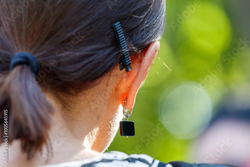 A woman with a ponytail and a black earring photo