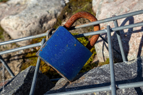 Single old rusty padlock lovelock attached to steel grid photo