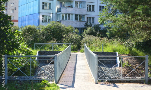 A narrow bridge over a small river near the house, Dybenko Street, St. Petersburg, Russia, July 15, 2024 photo