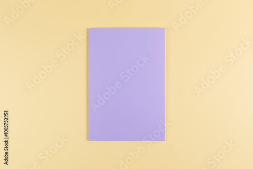 Top view of purple notebook on yellow background. School, office wallpaper. Flat lay, copy space.