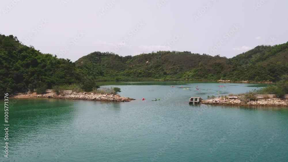 Aerial drone video of group of people kayaking into a lake surrounded by mountains. Aerial drone video of group of people kayaking into a lake surrounded by mountains.