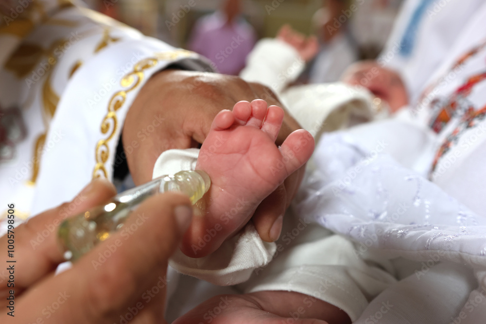 Fototapeta premium The priest performs the rite of baptism and anointing.
