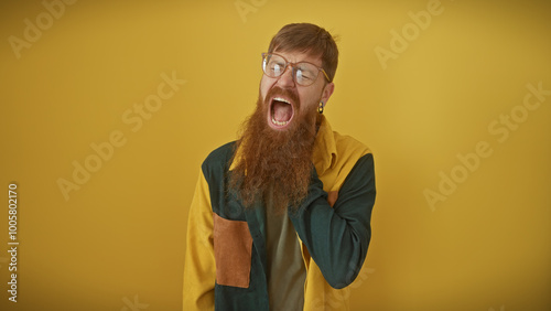 Billede på lærred A bearded, redhead man yelling with closed eyes against a yellow background, exemplifying frustration or excitement
