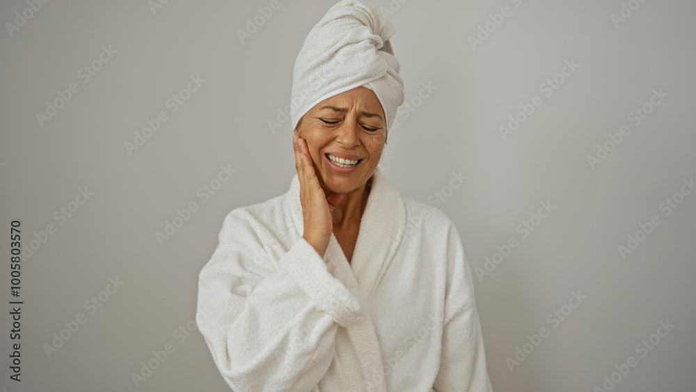 Woman in bathrobe with towel wrapped around head experiencing tooth pain isolated on white background