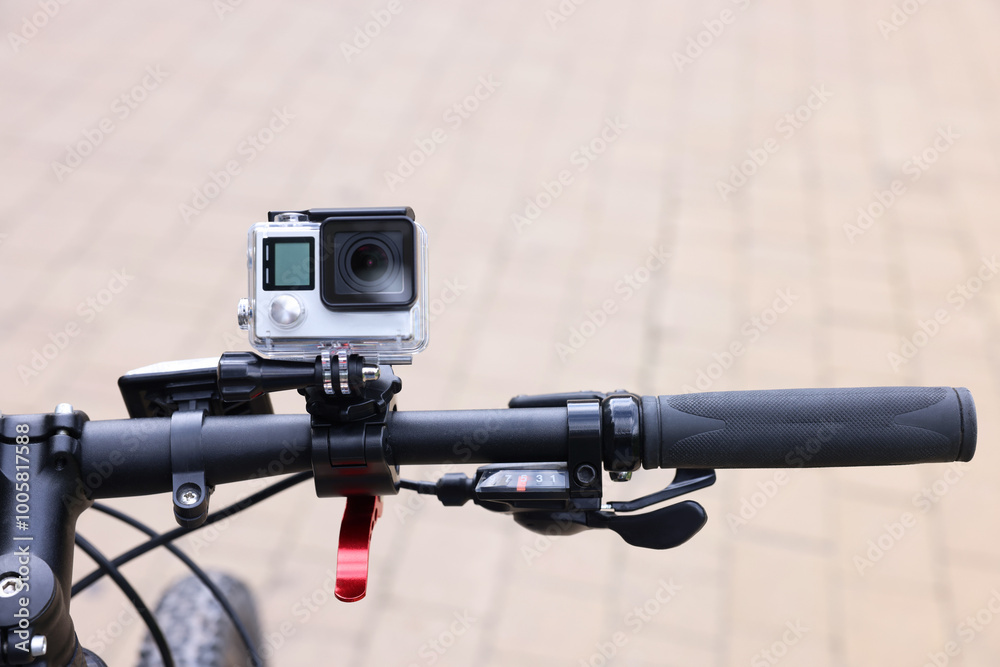 Modern action camera with mount on bicycle outdoors, closeup Modern action camera with mount on bicycle outdoors, closeup