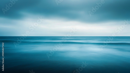 Wallpaper Mural A calm ocean with a cloudy sky in the background. The water is blue and the sky is gray Torontodigital.ca