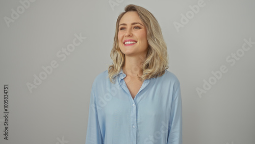 Portrait of a smiling young blonde woman in a blue shirt against a white background exudes beauty and simplicity.