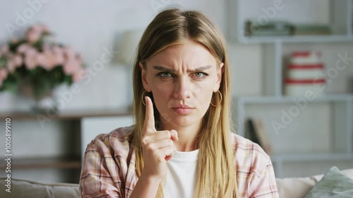A woman expresses disapproval with various gestures and facial expressions, waving her hand sitting in her living room. Her emotions reflect frustration and dissatisfaction with the current problem