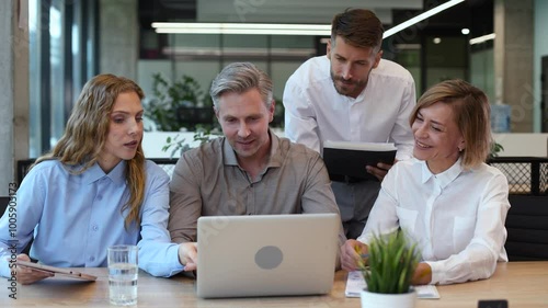 Group of young modern people in formalwear using modern technologies while working in the creative office