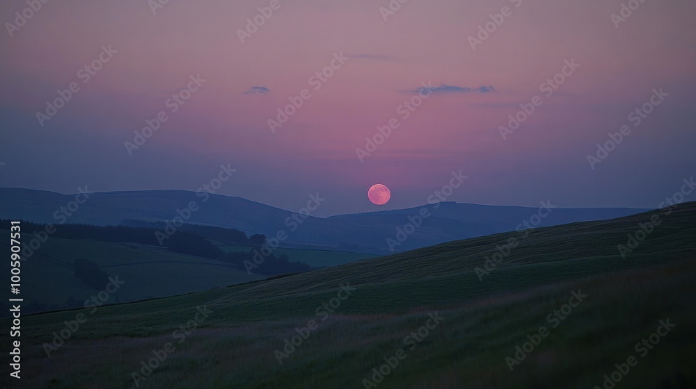 The Moon setting behind rolling hills, casting a soft glow over the landscape as dawn breaks on the horizon The Moon setting behind rolling hills, casting a soft glow over the landscape as dawn breaks on the horizon