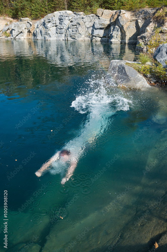 Obraz premium Diving man visible under transparent clear water of flooded old quarry in central Sweden near Romfartuna
