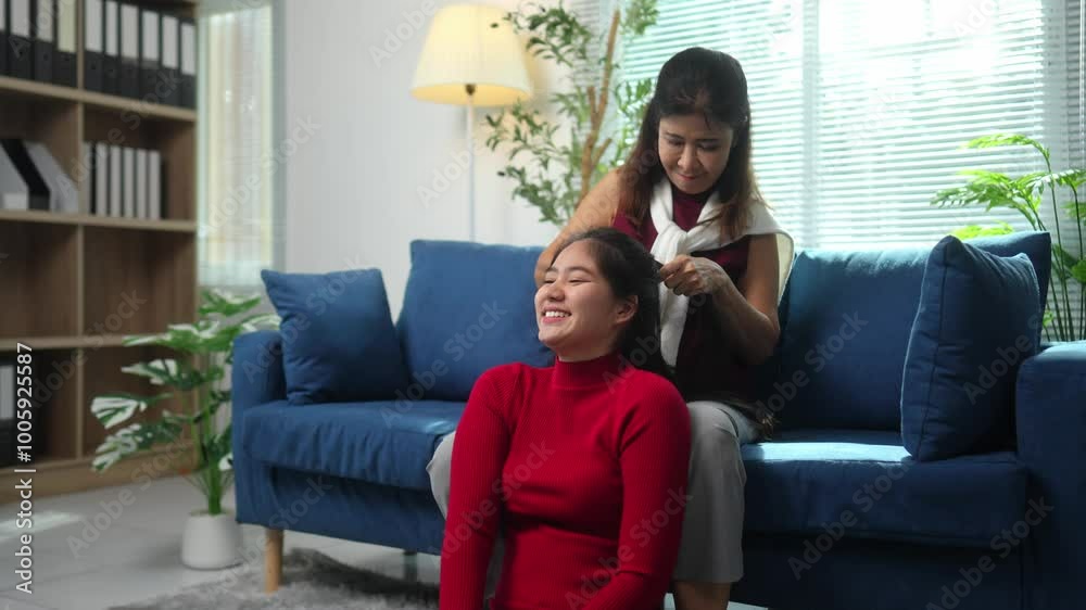 Happy Asian mother and daughter use laptop and watch online program on sofa in living room at home. Singing, dancing, doing happy family holiday activities together. Holiday concept. Happy Asian mother and daughter use laptop and watch online program on sofa in living room at home. Singing, dancing, doing happy family holiday activities together. Holiday concept.