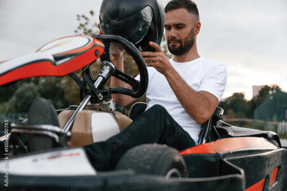 Wearing the safety helmet. Man is outdoors, kart racing conception Wearing the safety helmet. Man is outdoors, kart racing conception