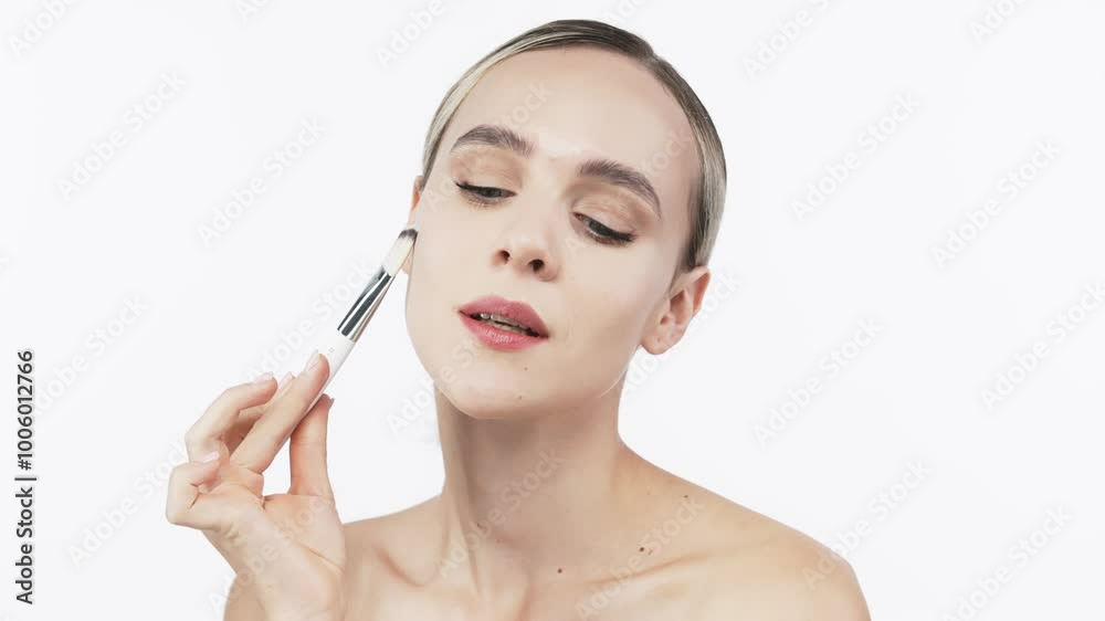 A young woman gently applies cream to her face with a brush. This tender touch emphasizes the importance of skincare and self-care, creating an atmosphere of relaxation and harmony. A young woman gently applies cream to her face with a brush. This tender touch emphasizes the importance of skincare and self-care, creating an atmosphere of relaxation and harmony.