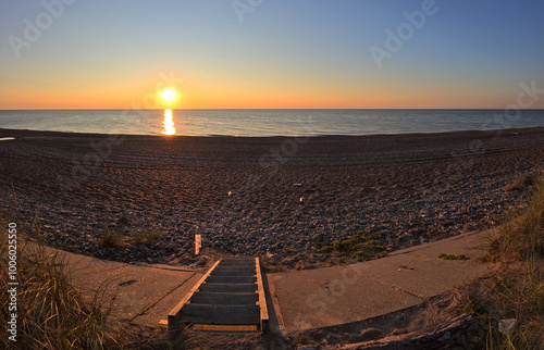 Wunderschöner Sonnenuntergang an der Küste - Küstenschutz mit Platten - Treppe zum Strand - Ruhe und Erholung im Urlaub an der Nordsee