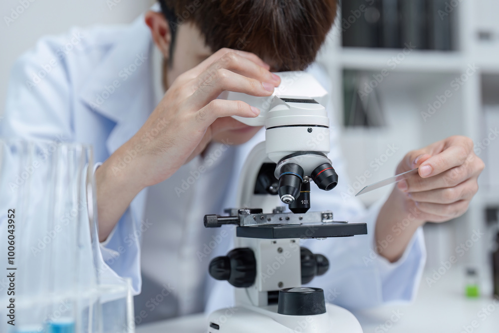 Researchers Analyzing Samples Under Microscope in Modern Laboratory for Scientific Study and Medical Research Researchers Analyzing Samples Under Microscope in Modern Laboratory for Scientific Study and Medical Research
