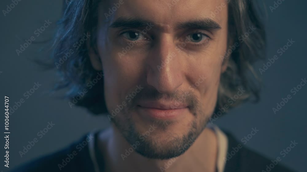 a young man with long hair, large expressive eyes, European appearance, looks into the frame, smiles mysteriously, languidly, kisses his lips, crooked white teeth a young man with long hair, large expressive eyes, European appearance, looks into the frame, smiles mysteriously, languidly, kisses his lips, crooked white teeth