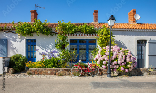 Fototapeta Naklejka Na Ścianę i Meble -  Vieux vélo rouge dans les rue d'un village de Vendée en France sur l'île de Noirmoutier.