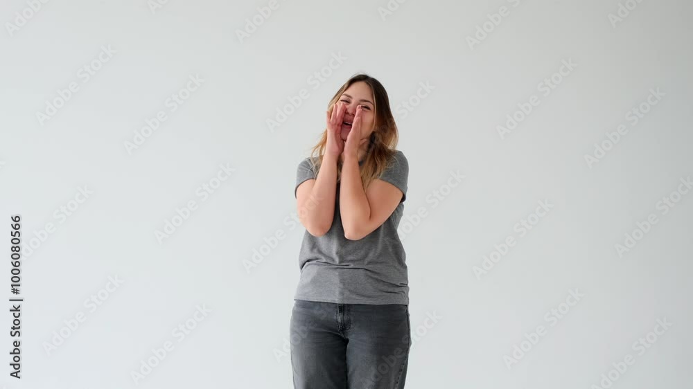 Happy Caucasian young woman shouting in hand loudspeaker, making announcement or advertisement on white background. Concept of a communication, news.