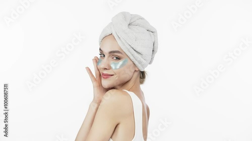 Wallpaper Mural A young woman with a towel on her head and under-eye patches relaxes against a white background, indulging in spa treatments. This image embodies the luxury of self-care and tranquility. Torontodigital.ca