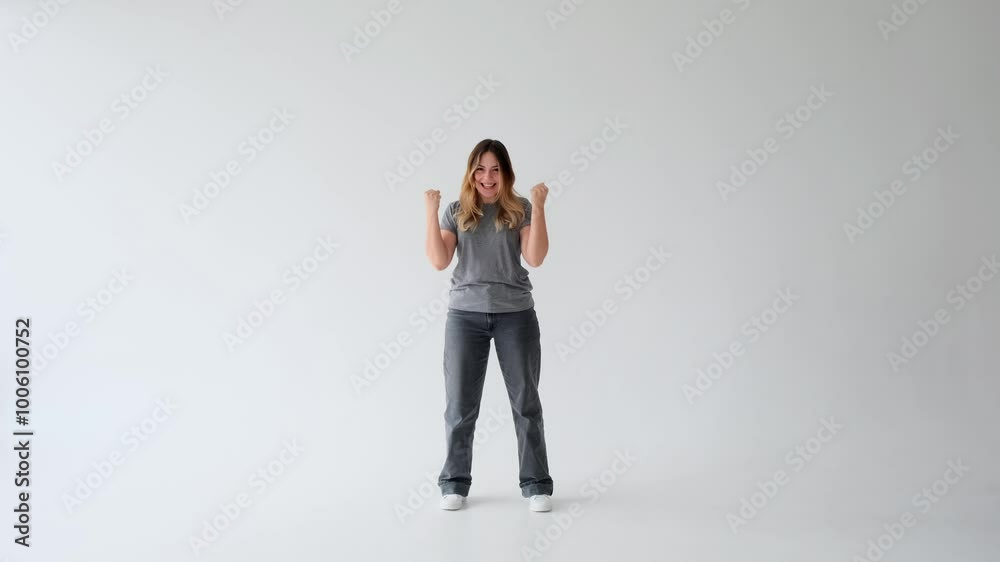 Cheerful and friendly Caucasian young adult woman applauding and exclaiming yes in celebration on white background. Good news, satisfaction and accomplishment concept. Cheerful and friendly Caucasian young adult woman applauding and exclaiming yes in celebration on white background. Good news, satisfaction and accomplishment concept.