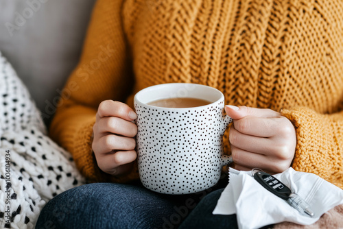 Woman in a warm mustard colored sweater holding a mug of tea