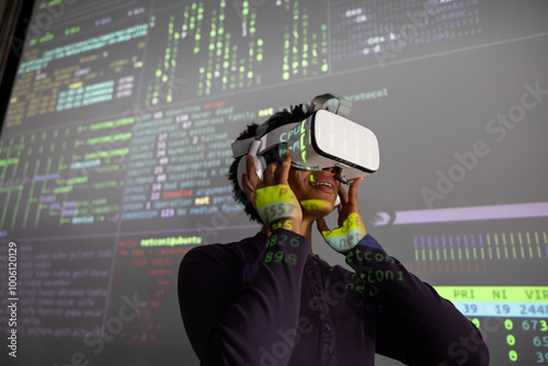 Coder testing VR headset with coding on large presentation screen  photo