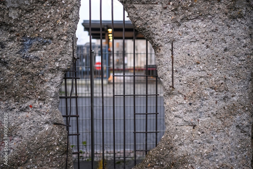 Hole in Broken Berlin wall and walking person against