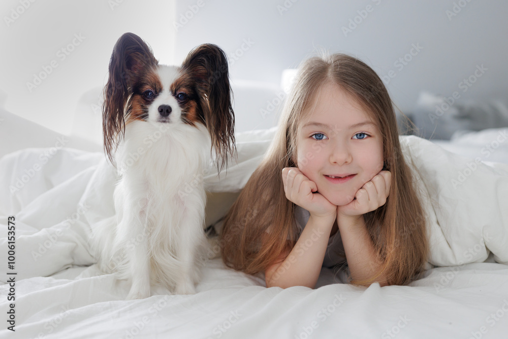 little preschool girl lying in bed with her cute dog