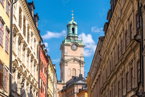 Historic Storkyrkan in Stockholm, Sweden, with its bell tower and clock, surrounded by traditional buildings. photo