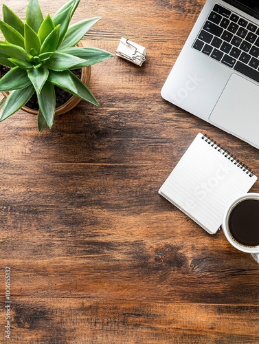 An overhead flat lay shot of a modern workspace setup on a rustic wooden desk.